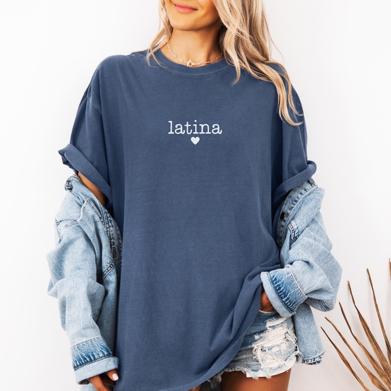 May include: A blue oversized t-shirt with the word "latina" and a small heart printed on the front.