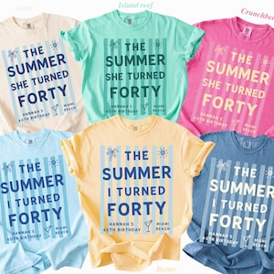May include: Six short-sleeve crew neck t-shirts in ivory, island reef, crunchberry, chambray, butter, and blue jean colors. Each shirt features vertical stripes and the text THE SUMMER SHE TURNED FORTY or THE SUMMER I TURNED FORTY with birthday details.