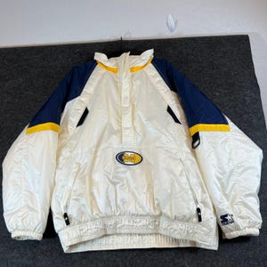 May include: A white, navy blue, and yellow pullover windbreaker jacket featuring a high collar, long sleeves, and a central oval patch with the text Michigan. The jacket includes a front zipper, side pockets, and a Starter logo on the sleeve.