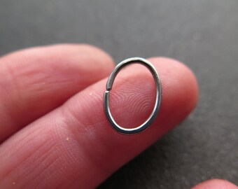 one single oval hoop earring in dark silver niobium. 18 gauge hypoallergenic hoop. oval earring.