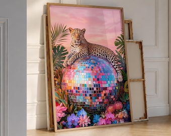 May include: A rectangular wall art print featuring a leopard resting atop a large, multi-colored disco ball. The scene is surrounded by vibrant tropical foliage and colorful flowers against a soft pink sky, all framed in a light wood border.