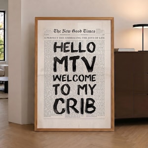 Peut inclure: Une affiche encadrée présentant une mise en page de journal vintage intitulée The New Good Times. Au centre, des lettres noires audacieuses peintes à la main indiquent HELLO MTV WELCOME TO MY CRIB sur des colonnes de petit texte imprimé.