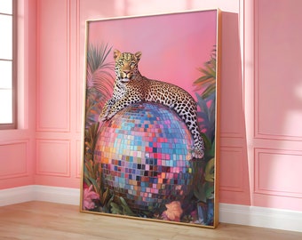 May include: A leopard sits on top of a disco ball in a pink and green tropical setting. The disco ball is made of mirrored tiles and reflects light.