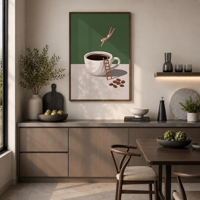 May include: A framed wall art print featuring a surreal illustration of a person diving into a large white coffee cup. A wooden ladder leans against the cup, which sits on a surface with scattered coffee beans against a dark green background.