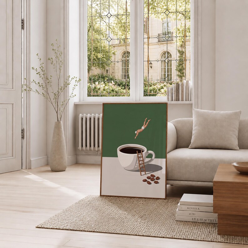 May include: A framed wall art print featuring a dark green background with a white coffee cup filled with black coffee. A small figure in white swimwear dives into the cup, while a wooden ladder leans against it and coffee beans lie nearby.
