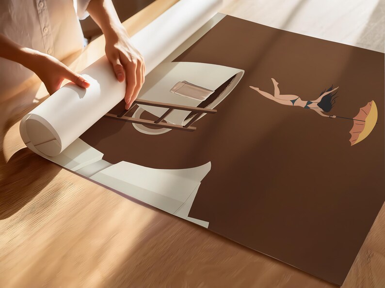 May include: A rolled-up print being unrolled, revealing a brown and beige illustration of a woman floating with an umbrella. The artwork features a ladder and architectural elements. The woman is wearing a bikini. The print is on a wooden surface.