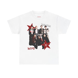 Op de afbeelding: Wit T-shirt met een afbeelding van een groep mensen, de tekst "BANGTAN BOYS" en rode sterren. De afbeelding toont een groep mensen in verschillende outfits, met de tekst in een gestileerd lettertype.
