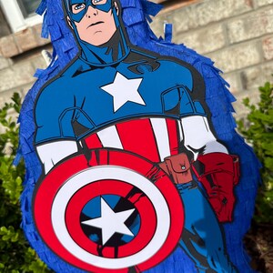May include: A blue and red Captain America pi&ntilde;ata with a white star on his chest and a red, white and blue shield.