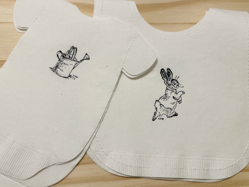 Baby shirt shaped or bib shaped linen-like paper napkins featuring Peter Rabbit. Baby shower napkins. Pack of 16. image 1
