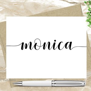 May include: A white card with the name "monica" written in black cursive script.