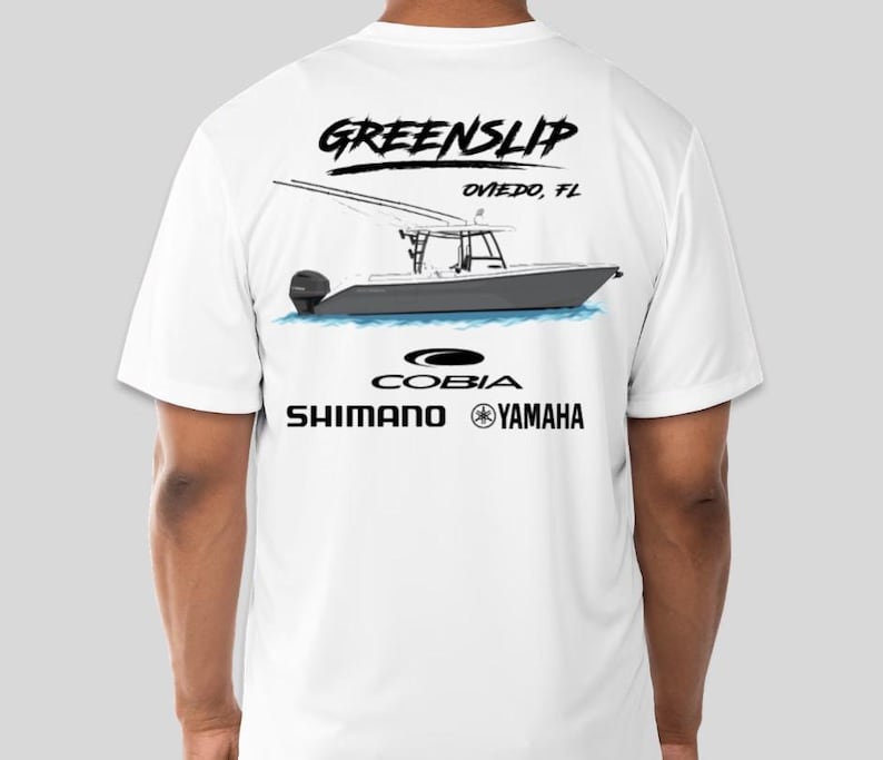 May include: White t-shirt with a black graphic of a boat, the text "GREENSLIP OVIEDO, FL", and the logos "COBIA", "SHIMANO", and "YAMAHA".