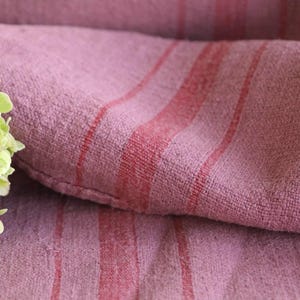 Puede incluir: Primer plano de una tela de rayas rosa y rojas con una superficie suave y texturizada.