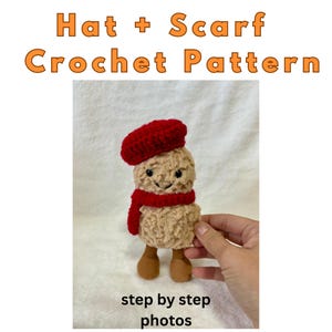May include: A crocheted figure wearing a red beret and scarf. The figure is beige with brown feet and a smiling face. The image includes the text "Hat + Scarf Crochet Pattern" and "step by step photos".