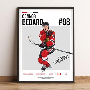 Op de afbeelding: Een ingelijste poster met een illustratie van ijshockeyspeler Connor Bedard in een rood, zwart en wit Chicago Blackhawks-shirt met nummer 98. De print bevat zijn naam, rugnummer, een handtekening en spelersstatistieken in zwarte tekst.