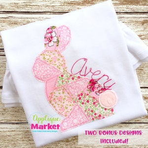 May include: A white babygrow with a pink patchwork bunny applique and the name "Avery" embroidered in pink thread. The babygrow has a frilled neckline and is ideal for a baby girl.