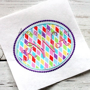 May include: A purple and blue beaded circle with a colorful diamond pattern and the letters "KWA" in pink inside.
