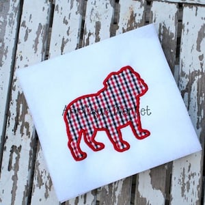 May include: Red and black checkered bulldog silhouette embroidered on a white t-shirt.