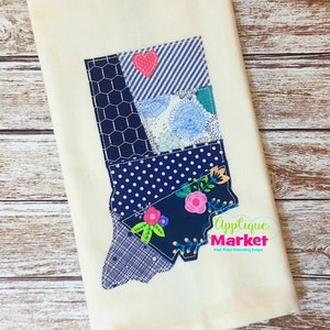 May include: A white fabric kitchen towel with a blue and white patchwork design of the state of Indiana. The design includes a red heart, blue and white polka dots, and floral patterns. The text "Applique Market" is in the lower right corner.
