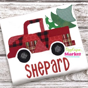 May include: Red patchwork truck carrying a green Christmas tree with the name "Shepard" embroidered below.