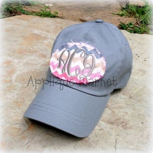 May include: Gray baseball cap with a pink, brown, and gray chevron patterned fabric patch with the monogram "AC9" embroidered on it.