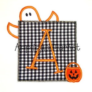 May include: Orange felt letter A with a ghost and a pumpkin bucket on a black and white gingham background.