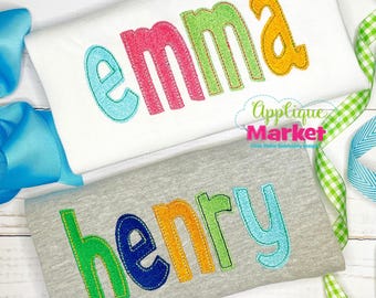 Op de afbeelding: Twee kindershirts, één wit en één grijs, elk geborduurd met een naam in kleurrijke letters. Het witte shirt zegt "EMMA" in roze, groen, blauw en geel. Het grijze shirt zegt "henry" in groen, blauw, oranje en blauw.