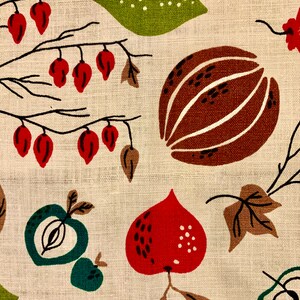 May include: A beige fabric with a repeating pattern of red, green, and brown fruits and leaves. The fruits are stylized and resemble apples, pears, and gourds. The leaves are brown and green.