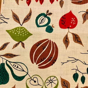 May include: A beige fabric with a repeating pattern of green, brown, and red fruits and leaves. The fruits include pears, apples, and a type of citrus fruit. The leaves are brown and green.