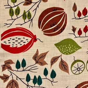 May include: A beige fabric with a repeating pattern of brown, red, and green stylized fruits and leaves. The pattern is abstract and reminiscent of a vintage textile design.