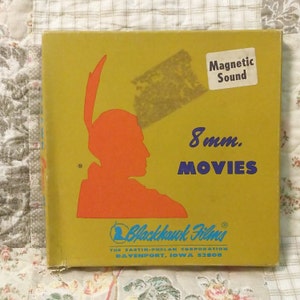 May include: A yellow box with a blue and orange illustration of an American Indian. The box is labeled "Blackhawk Films" and "8mm. MOVIES" with the text "Magnetic Sound" in a white box. The box is for 8mm film reels.