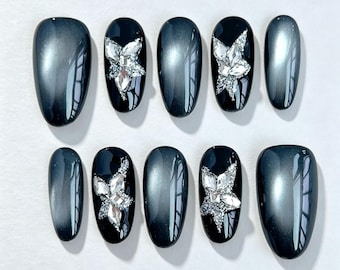 Uñas postizas con efecto ojo de gato y bolas luminosas en color negro brillante, uñas personalizadas con estrellas brillantes, uñas elegantes, uñas postizas, uñas geniales, uñas elegantes