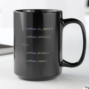 May include: A black coffee mug with white text that reads "if coffee.is_empty(): coffee.refill() else: coffee.drink() coffee.code()". The mug is sitting on a white surface.