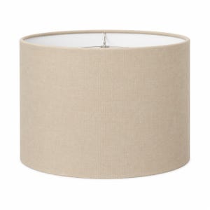 May include: A cylindrical drum lampshade featuring a textured beige fabric exterior and a smooth white interior lining. The top opening reveals a central metal spider fitter hardware component designed for attachment to a lamp base structure.