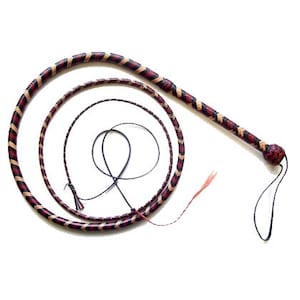 Puede incluir: Un látigo trenzado con un mango y un largo látigo en espiral. El látigo presenta un patrón de secciones rojas, beige y negras alternas. El mango es de un rojo más oscuro con un extremo anudado y un lazo negro.