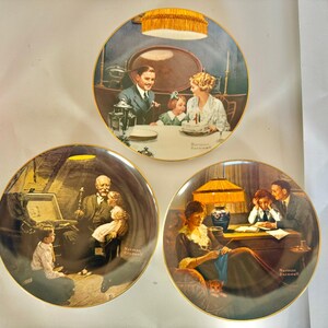 May include: Set of three decorative plates featuring Norman Rockwell illustrations. Each plate has a gold rim and depicts a different family scene, including a birthday celebration, a grandfather with children, and a mother knitting.