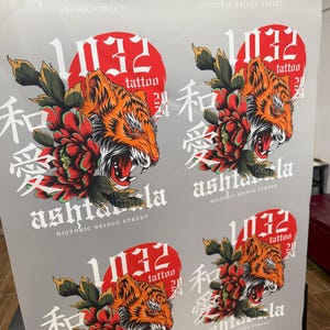May include: A repeating pattern of a red circle with the number 1032 and the word "tattoo" inside. The circle is surrounded by a tiger with a red flower and the Japanese characters "和" and "愛" in black. The text "ashtala" and "HISTORIC BRIDGE STREET" are also included in the design.