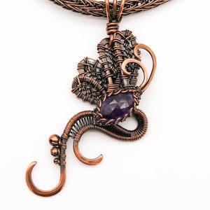 May include: A copper wire necklace with a pendant featuring a purple amethyst gemstone and intricate wirework.