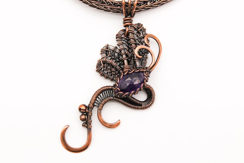 May include: A copper wire necklace with a pendant featuring a purple amethyst gemstone and intricate wirework.