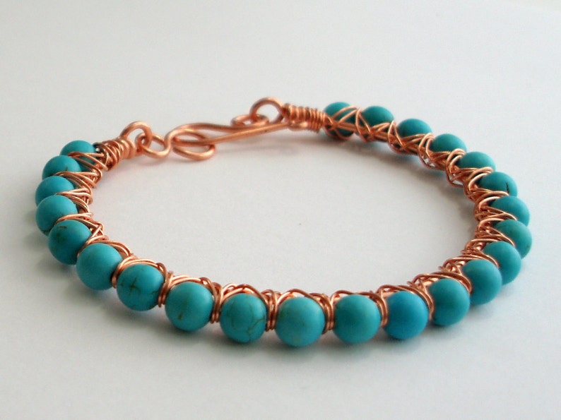 May include: A copper wire wrapped bracelet with turquoise blue beads.