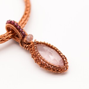 May include: A copper wire wrapped pendant necklace with a pink rose quartz stone and small pink beads.