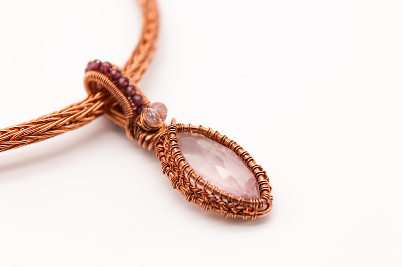 May include: A copper wire wrapped pendant necklace with a pink rose quartz stone and small pink beads.