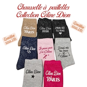 Op de afbeelding: Een collectie van acht glitterende sokken in diverse kleuren, waaronder goud, zwart, marineblauw, roze, grijs en magenta. Elke sok is voorzien van bedrukte teksten en afbeeldingen gerelateerd aan Céline Dion, zoals Paris, 2026 en songteksten.