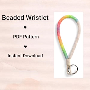 May include: A beaded wristlet with a rainbow gradient design. The wristlet transitions from pink to yellow to green, and then to white. It has a metal ring and a loop for attaching keys or other small items. The text "Beaded Wristlet" is above the image.