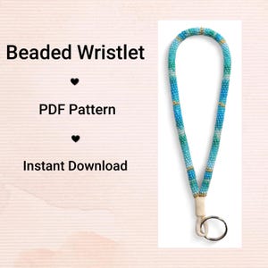 Pode incluir: Uma pulseira de contas em tons de azul e verde com detalhes dourados. A pulseira é presa a um cordão creme e a um anel prateado. O texto à esquerda diz "Beaded Wristlet", "PDF Pattern" e "Instant Download".