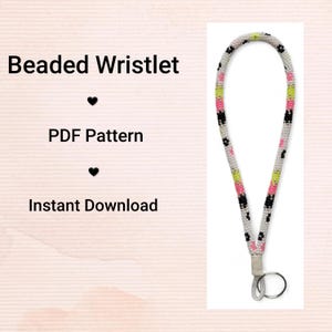 May include: A beaded wristlet featuring a pattern of white, black, pink, and green beads. The wristlet has a silver-coloured clasp and key ring. Text on the left side reads "Beaded Wristlet", "PDF Pattern", and "Instant Download".