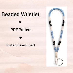 Peut inclure: Un bracelet porte-clés perlé avec un motif répétitif de perles bleu clair, blanches et noires, fixé à un anneau en métal argenté. Le texte Beaded Wristlet, PDF Pattern et Instant Download est affiché à gauche du bracelet.