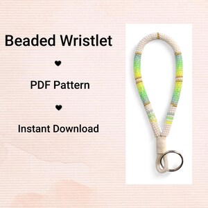 Pode incluir: Uma pulseira de contas com base branca, acentuada com contas verdes, amarelas e douradas. A pulseira tem um design de laço e um porta-chaves prateado. O texto à esquerda diz "Beaded Wristlet", "PDF Pattern" e "Instant Download".