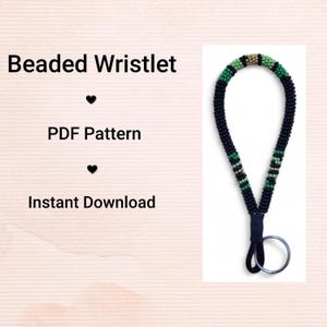 May include: A beaded wristlet in a dark blue and green design. It features a silver key ring. The text on the left reads "Beaded Wristlet", "PDF Pattern", and "Instant Download".