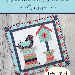 May include: A blue bird with a red roof birdhouse and a spool of thread on a white background. The quilt block is surrounded by a red, white, and blue floral border. The text "Feathered Friends ~Summer~" is at the top of the image. The text "#338" is at the bottom left of the image. The text "This & That Original Quilt Patterns by Sherri K. Falls" is at the bottom right of the image.