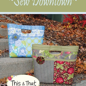 May include: Two fabric tote bags with different patterns. The bag on the left is blue and white with floral designs. The bag on the right is gray and brown with a floral design and stripes. Both bags have a cut-out handle. The bags are sitting on a set of concrete steps with fall leaves around them. The text "This & That" is on a white oval with a black outline. The text "Original Quilt Patterns by Sherri K. Falls" is below the oval. The text "#232" is in the bottom right corner.